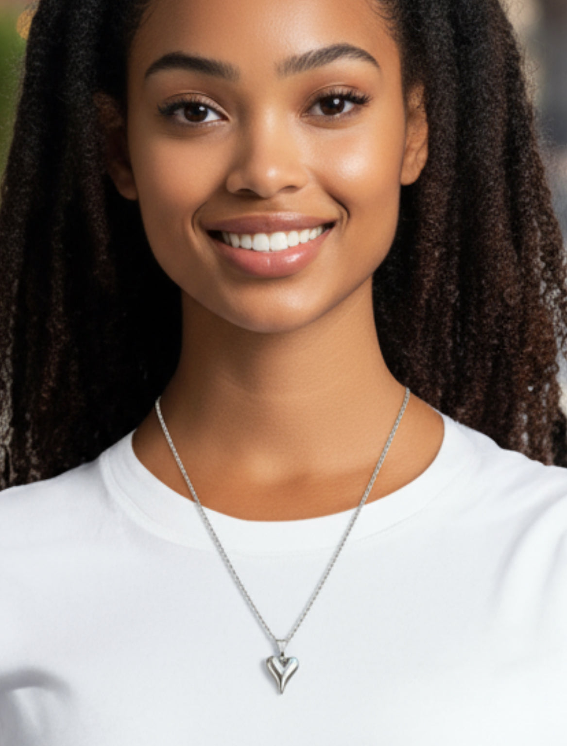 Woman wearing a silver necklace with a heart pendant 